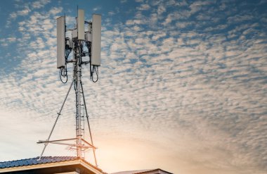 Telekomünikasyon kulesi mavi gökyüzü ve beyaz bulutlar arka planda. Mavi gökyüzünde anten. Radyo ve uydu direği. İletişim teknolojisi. Telekomünikasyon endüstrisi. Cep telefonu ya da telekom 4G ağı.