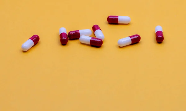 黄色背景的抗生素胶囊丸 制药工业 处方药 红白胶囊丸医药产品 药学网站的横幅 健康保险和健康预算 — 图库照片