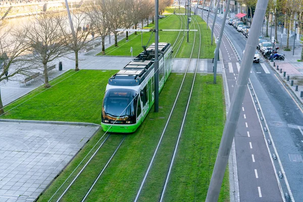 18 Aralık 2021 'de, Euskotren tramvay tramvayı tramvay hattında ilerliyor. Avrupa 'da modern ulaşım. Akıllı şehir. Nehir kıyısındaki şehir rampasının üstünde. Elektrikli araç. Yeşil taşıma.
