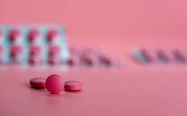 Bulanık pakette yuvarlak pembe tablet hapı. Reçeteli ilaç. Pembe arka planda ağrı kesici ya da antibiyotik hap. İlaç sanayisi. Sağlık ve refah geçmişi. İlaç konsepti