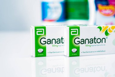 CHONBURI, THAILAND-NOVEMBER 22, 2021 Abbott Laboratuvarları 'nın Ganaton ürünü. Bulanık ilaç şişelerinin arka planında karton kutudaki Ganaton tabletleri. Ülser olmayan hazımsızlık için reçete yazılıyor..