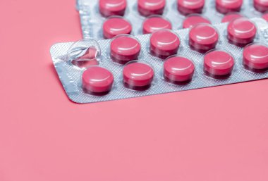 Hap konseptini al. Pembe haplar, pembe arka plandaki su toplayan paketlerde. Reçeteli ilaç. İlaç sanayisi. Hap hatırlatıcısı ya da ilaç hatırlatıcısı. Vitamin, mineral ve takviye..