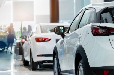 Dikiz ayarı beyaz SUV araba modern lüks galeride bulanık satış elemanı ve müşteri. Araba galerisi ofis konsepti. Dağıtıcı ajan işi. Otomobil kiralama servisi. Krupiye şirketi. Yeni araba alımı.
