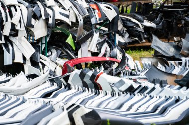 Kullanılmış ön tampon yığını, arka tampon ve geri dönüşüm için araba spoiler. Karbon fiber, PU ve plastik otomobil parçaları. Otomotiv endüstrisi. Hurdalık dolusu eski tampon, spoiler. Plastik atık.