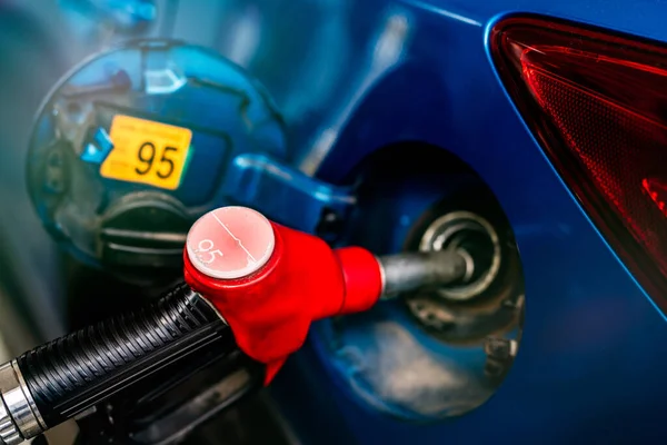 Car fueling at gas station. Refuel fill up with petrol gasoline. Petrol pump filling fuel nozzle in fuel tank of car at gas station. Petrol industry and service. Petrol price and oil crisis concept.