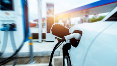 EV araba açık hava elektrikli araba şarj istasyonunda şarj oluyor. EV araba şarj noktası. Elektrikli araç hızlı şarj konsepti. DC hızlı şarj istasyonu. Hızlı şarj konsepti. Sürdürülebilir güç. Yeşil enerji.