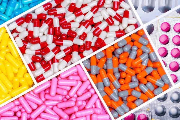 Top view of antibiotic capsules and tablet pills. Antibiotic drug resistance. Superbug. Full frame of multi-colored pills. Pharmaceutical industry. Prescription drugs. Healthcare and medicine.