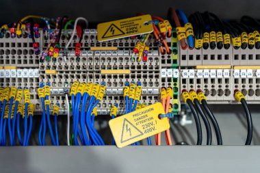 Endüstriyel fabrikadaki makinelerin elektrik şeması. Etiket ve uyarı etiketli terminal diyagramı. Yüksek voltajlı elektrik teli. Otomasyon makineleri kontrol paneli. Elektrik kontrol dolabı.