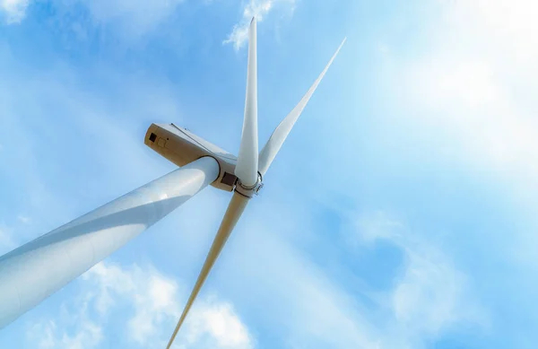 Wind energy. Wind power. Sustainable, renewable energy. Wind turbines generate electricity. Windmill against blue sky and sun light. Green technology. Renewable resource. Sustainable development.