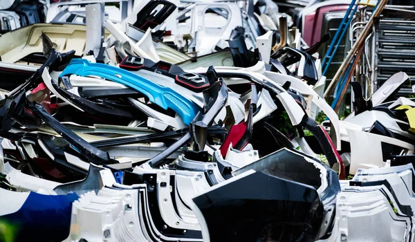 Kullanılmış ön tampon yığını, arka tampon ve geri dönüşüm için araba spoiler. Karbon fiber, PU ve plastik otomobil parçaları. Otomotiv endüstrisi. Hurdalık dolusu eski tampon, spoiler. Plastik atık.