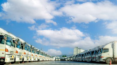 Fleet of trucks parked at parking lot yard of delivery company. Truck transport. Logistic industry. Freight transportation. Truck leasing. Commercial truck for delivering goods from warehouse. Cargo