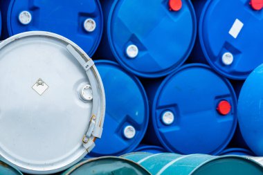 Eski kimyasal variller. Mavi ve yeşil yağ varili. Çelik ve plastik yağ tankı. Zehirli atık deposu. Uyarı etiketli tehlikeli kimyasal varil. Davulda endüstriyel atık. Fabrikada atık depolama. 