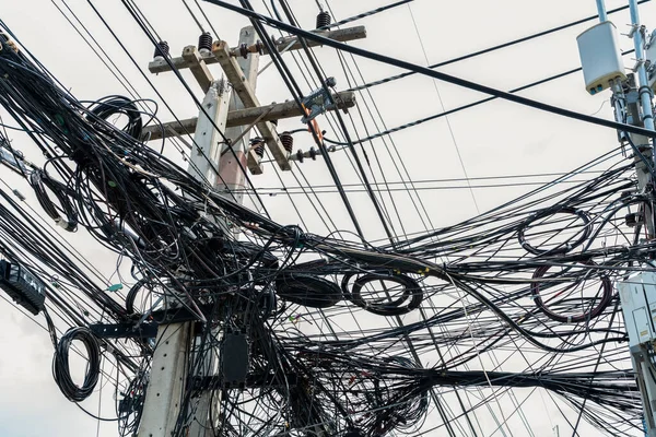 Tangled electrical wires on urban electric pole. Disorganized and messy to organization management concept. Closeup tangled electrical wires . Should take underground wire for beautiful landscape.