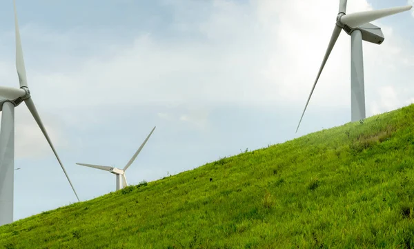 Wind energy. Wind power. Sustainable, renewable energy. Wind turbines generate electricity. Windmill farm on a mountain with blue sky. Green technology. Renewable resource. Sustainable development.