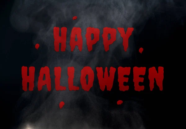 Happy Halloween on black background and smoke. Halloween day night party backdrop. Halloween day wallpaper. Red Happy Halloween creepy text on black background for advertisement. October holiday.