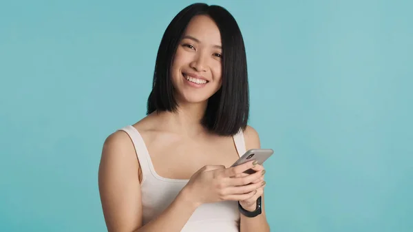 Onnellinen Aasialainen Nainen Kirjoittaa Tekstiviestin Älypuhelimeen Nauttien Online Viestinnästä Värikkäällä — kuvapankkivalokuva