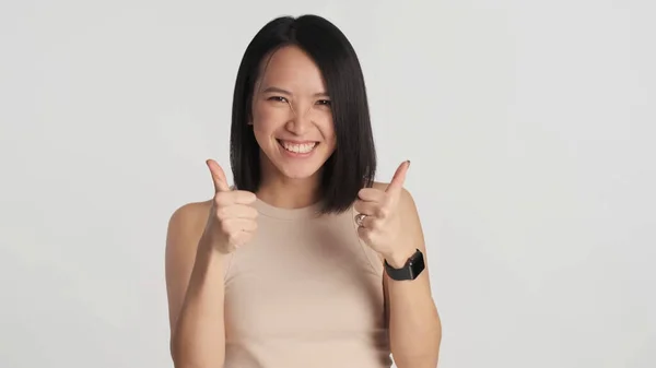 Iloinen Aasialainen Nainen Pitää Peukalo Nosti Osoittaa Hänen Suostumuksensa Valkoisella — kuvapankkivalokuva