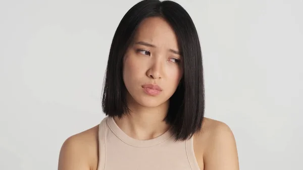 Lähikuva Surullinen Aasialainen Nainen Näyttää Masentunut Seisoo Valkoisella Taustalla Tyytymätön — kuvapankkivalokuva