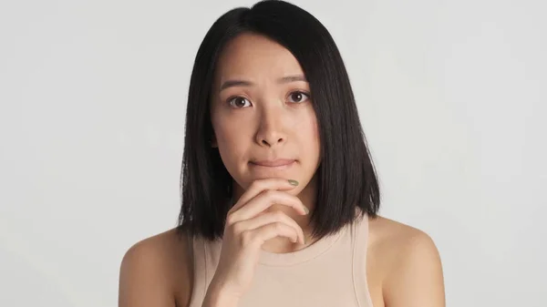 Asiatisk Kvinne Holder Hender Hakebitende Lepper Ser Tankefullt Kamera Hvit – stockfoto