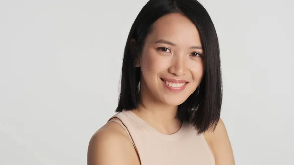 Muotokuva Aasialaisesta Naisesta Joka Hymyilee Kameralle Valkoisella Taustalla Kasvojen Ilme — kuvapankkivalokuva