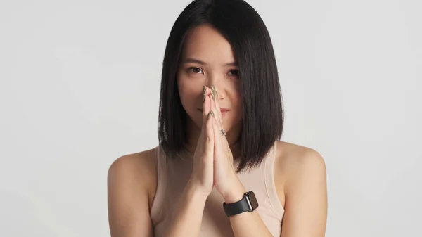 Jovem Mulher Asiática Fazendo Desejo Mãos Dadas Sobre Fundo Cinza — Fotografia de Stock