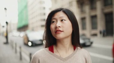Güzel Asyalı bir kadının rahat bir caddede yürürken esinlendiği ağır çekimde. Uzun saçlı Asyalı kız yeni şehri keşfediyor.