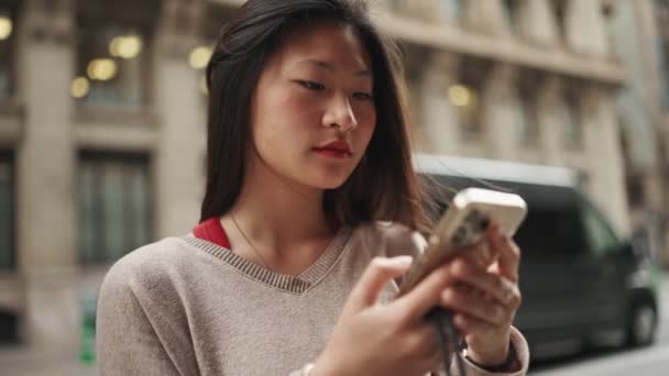 Şehir Caddesinde Duran Uzun Saçlı Asyalı Kadının Akıllı Telefon Kullanmasının — Stok video