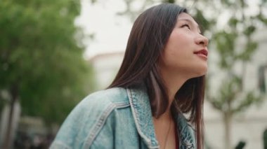 Uzun saçlı Asyalı bir kadının kablosuz kulaklık kullanarak arkadaşıyla konuşmasını engelle. Çekici kız dışarıda dinleniyor.