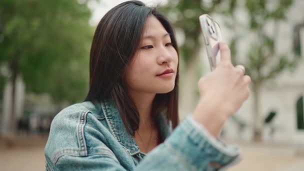 Vacker Långhårig Asiatisk Kvinna Ser Inspirerad Bilder Vacker Stad Smartphone — Stockvideo