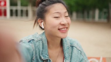 Dost canlısı Asyalı kız video blogu için içeriği kaydediyor. Sokaklarda iyi günlerin tadını çıkarıyor. Sosyal medya içeriği