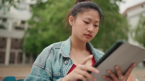 재킷을 공부하기 태블릿 사용하는 아시아 여학생 야외에서 공부하는 매혹적 여대생 — 비디오
