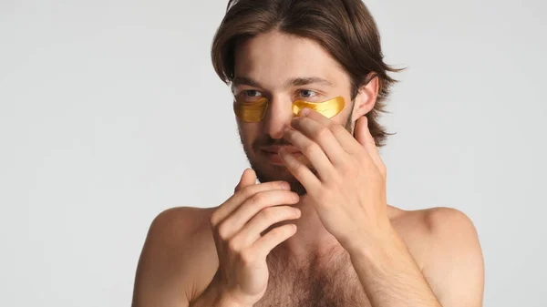 Beautiful Brunette Bearded Man Applying Gold Eye Patches Taking Care — Stock Photo, Image