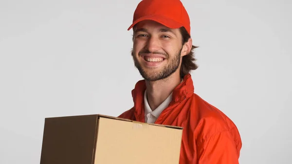 Bonito Homem Entrega Vestindo Uniforme Vermelho Segurando Caixa Papelão Sinceramente — Fotografia de Stock