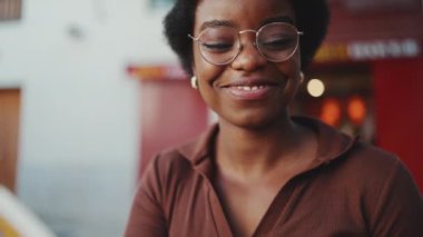 Afrikalı kızı rahat bir şekilde dışarıda ilginç kitaplar okurken yakın çekimde çek. Gözlüklü kadın. Mutlu yüz ifadesi