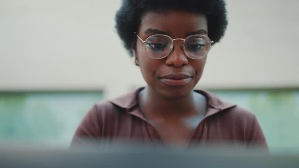 Gözlüklü Kıvırcık Saçlı Kız Dizüstü Bilgisayarla Çalışırken Çok Ciddi Görünüyor — Stok video