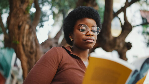 African Curly Haired Girl Reading Book Outdoors Wearing Glasses Female Stock Image
