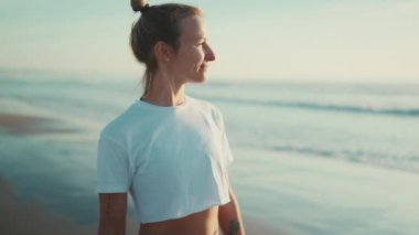 Yoga çalışmasından sonra deniz kenarında yürüyen güzel sarışın kadın. Sportif kız güzel görünüyor Sahilde sabahın tadını çıkarıyor