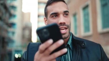 Kapatın çekici esmer adam dışarıdaki akıllı telefondan sesli mesaj kaydediyor. İletişim kurmak için cep telefonunu kullanan genç adam mutlu görünüyor.