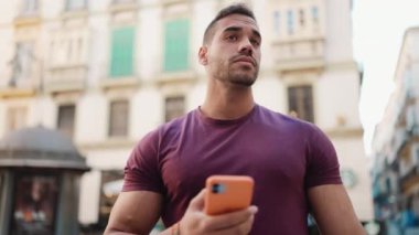 Genç esmer adam dışarısı için akıllı telefon kullanarak doğru yeri bulmaya çalışıyor. Şehirde yeniyim.