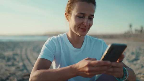 Lähikuva Kaunis Nainen Tarkkailun Hänen Sosiaalisen Median Avulla Älypuhelin Meren — kuvapankkivalokuva