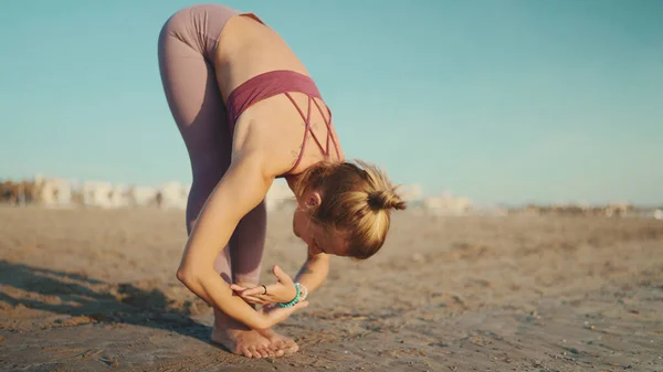 Stilig Blond Kvinne Med Sportstøy Som Nyter Yogatrening Ved Havet – stockfoto