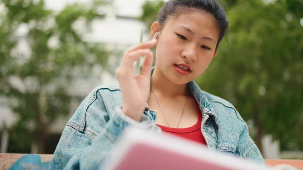 Konsentrert Asiatisk Jente Trådløse Øretelefoner Som Sitter College Noterer Kvinnelige – stockfoto