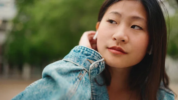 Närbild Ganska Asiatisk Kvinna Bär Trådlösa Hörlurar Lyssna Musik Gatan — Stockfoto
