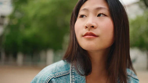 Nær Langhåret Asiatisk Kvinne Som Ser Tankefull Mens Hun Hviler – stockfoto