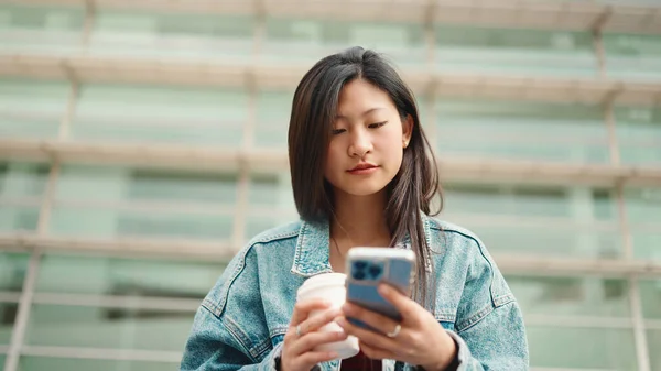 Vonzó Ázsiai Ellenőrzi Okostelefonját Szabadban Ülve Kávéval Női Diák Élvezi — Stock Fotó