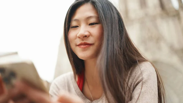 关闭亚洲黑发女孩检查她的社交媒体使用智能手机在街上 漂亮的亚洲女人在户外看起来很快乐 现代技术 — 图库照片