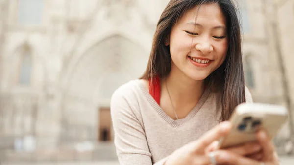 Lukk Den Langhårete Asiatiske Jenta Som Sitter Utendørs Ser Glad – stockfoto