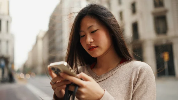 美丽的长发亚洲女人在智能手机上使用地图 试图在街上找到合适的位置 亚洲女孩独自探索新城市 — 图库照片