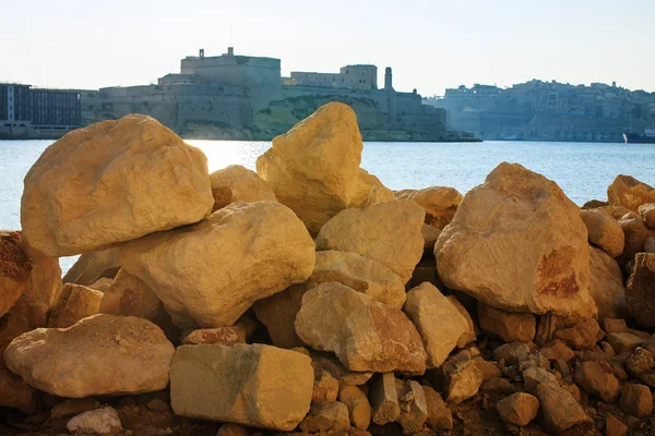 Mirar la ciudad a través de grandes piedras, Malta —  Fotos de Stock