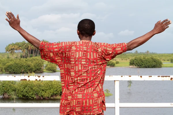 Africanos meditando brazos levantados lago . Imágenes De Stock Sin Royalties Gratis